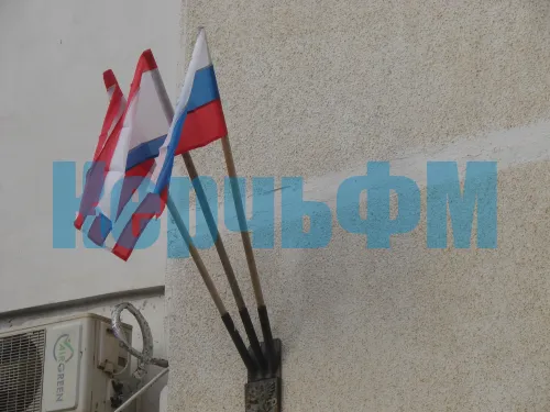 Новости » Общество: На доме по Кирова, 119 в Керчи заменили порванные ветром флаги